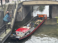 903636 Afbeelding van een de schuit Havendienst 8 van de gemeentelijke reinigings- en havendienst met afval uit de ...